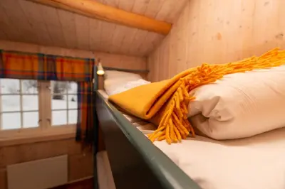 a bedroom with two bunk beds and a window at Nordpå Fjellhotell AS in Haltdalen