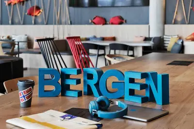 a break sign on a wooden table with a laptop at Moxy Bergen in Bergen