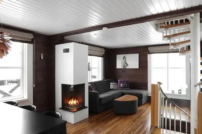 a living room with a couch and a fireplace at Mosetertoppen Panorama anneks 3B in Hafjell