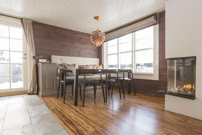 a dining room with a table and chairs and a fireplace at Mosetertoppen Panorama anneks 3B in Hafjell