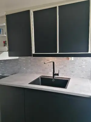 a kitchen counter with a sink and two windows at Sommerstue Hessdalen in Ålen