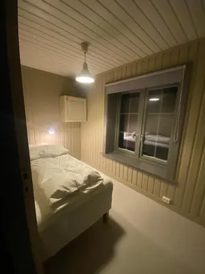 a small bedroom with a bed and a window at Nordre Fossheim Gård Hemsedal in Hemsedal