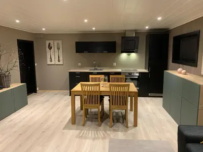a kitchen and dining room with a table and chairs at Lom Apartment in Lom