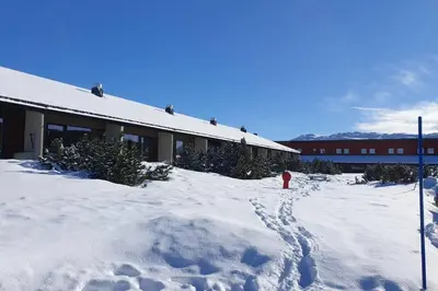 a red fire hydrant in the snow next to a building at Stor barnevennlig leilighet in Hovden