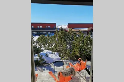 a view of a patio with snow and orange chairs at Stor barnevennlig leilighet in Hovden