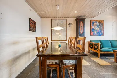 a dining room with a wooden table and chairs at Stor barnevennlig leilighet in Hovden