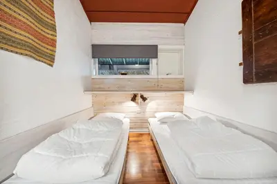 two beds in a room with white walls at Stor barnevennlig leilighet in Hovden