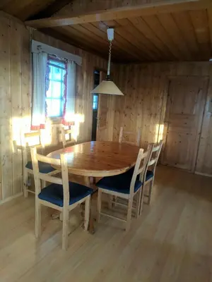 a wooden dining room table and chairs in a room at Toppen in Flatåker