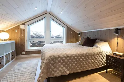 a bedroom with a bed and a large window at Lykkeli in Stranda