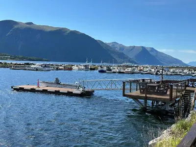 a dock with a boat in a body of water at 6 person holiday home in EIDSVÅG-By Traum in Eidsvåg