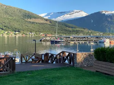 a dock with a bench and a marina on a lake at 6 person holiday home in EIDSVÅG-By Traum in Eidsvåg
