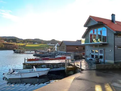 a boat parked at a dock next to a house at Holiday Home Jektastøo by Interhome in Nordhuglo