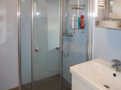 a shower with a glass door next to a sink at Holiday Home Jektastøo by Interhome in Nordhuglo
