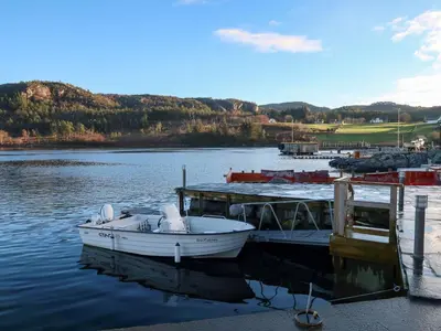 a boat is docked at a dock on a lake at Holiday Home Jektastøo by Interhome in Nordhuglo