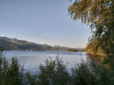 a view of a lake with mountains in the background at Teigen Leirstad, feriehus og hytter in Eikefjord