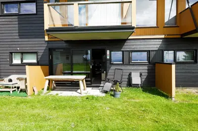 a house with a table and chairs in the yard at Lys og moderne leilighet rett ved skiløypa på Nordseter - Kort vei til Sjusjøen, Lillehammer og Hafjell - Dyr ikke tillatt in Nordseter