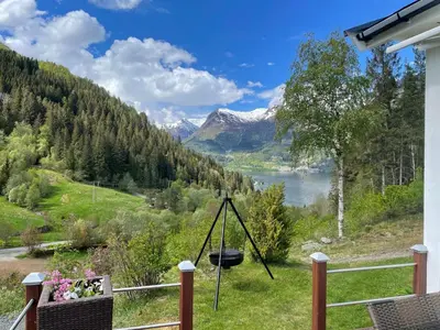 a balcony with a view of a lake and mountains at Tunold Gård - Kårhus in Mindresunde