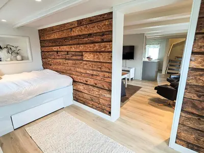 a bedroom with a wall made out of logs at 6 person holiday home in Bud in Bud