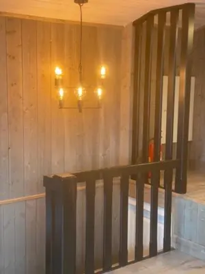 a chandelier in a room with a wooden wall at Villa Solsiden Geilo in Geilo