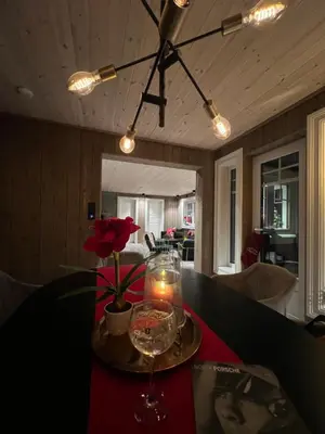 a table with a candle and a vase with a flower at Villa Solsiden Geilo in Geilo
