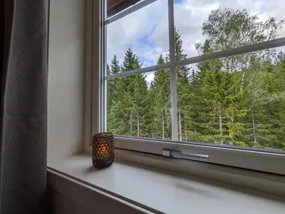 a window with a candle sitting on a window sill at Villa Fregn in Ljørdal