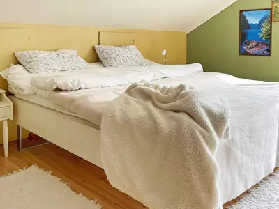 a bedroom with a white bed with a blanket on it at 8 person holiday home in Austefjorden in Austefjorden