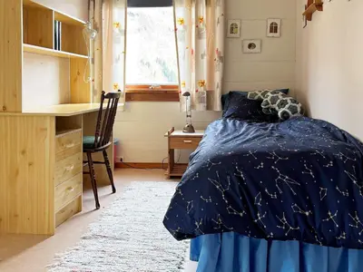 a bedroom with a bed and a desk and a window at 8 person holiday home in Austefjorden in Austefjorden