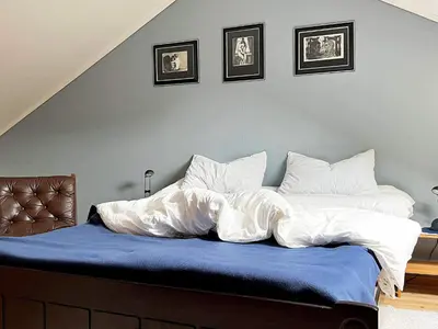 a bed with a blue blanket and two pillows at 8 person holiday home in Austefjorden in Austefjorden