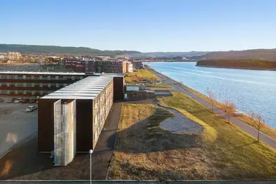 a building next to a body of water at Aiden by Best Western Trondheim Airport in Stjoerdal