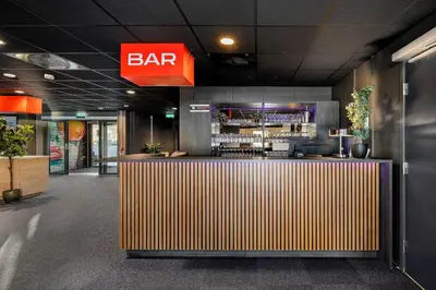 a bar in a restaurant with a bar sign on the wall at Aiden by Best Western Trondheim Airport in Stjoerdal