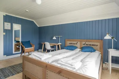 a bedroom with a large bed with blue walls at Dale-Gudbrands Gard by Frich`s in Sør-Fron
