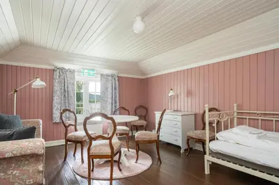 a bedroom with a bed and a table and chairs at Dale-Gudbrands Gard by Frich`s in Sør-Fron