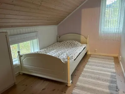 a bedroom with a bed in a room with a window at Stille og fredelig med panoramautsikt in Valsøybotn
