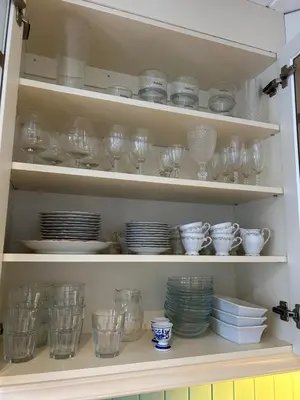 a cupboard filled with lots of glasses and plates at Stille og fredelig med panoramautsikt in Valsøybotn