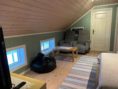 a living room with a couch and a table at Stille og fredelig med panoramautsikt in Valsøybotn