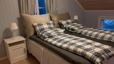 a couch with two pillows on it in a room at Stille og fredelig med panoramautsikt in Valsøybotn