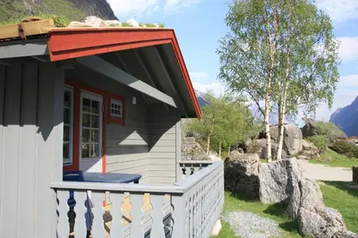 a small house with a red awning on a porch at Melkevoll Bretun Camping in Briksdalsbre