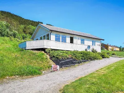 a house on top of a hill with a gravel road at 5 person holiday home in averøy in Stokke