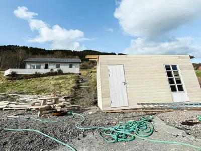 a small house with a shed in front of it at 5 person holiday home in averøy in Stokke