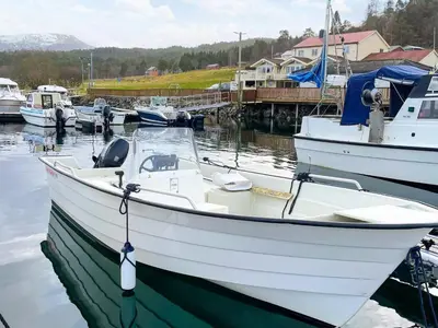 a white boat is docked in the water at 5 person holiday home in averøy in Stokke