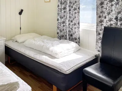 a bed and a chair in a room at 5 person holiday home in averøy in Stokke