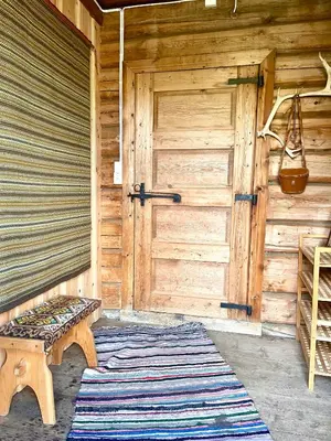 a wooden door and a bench in front of a door at Reinheimen Lodge in Skjåk