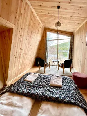a large bed in a room with a large window at Reinheimen Lodge in Skjåk