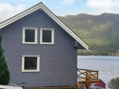 a house on the shore of a body of water at 8 person holiday home in Svelgen in Svelgen