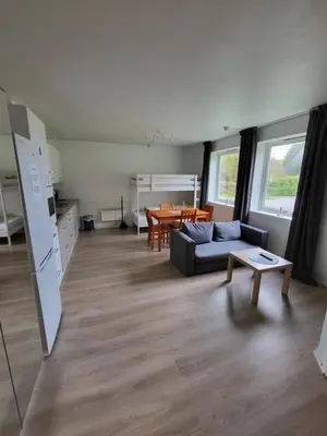 a living room with a couch and a table at Vollvaagen Apartments Smøla, boat included in Smøla