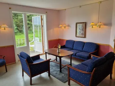 a living room with a couch and a table and chairs at Vollvaagen Apartments Smøla, boat included in Smøla