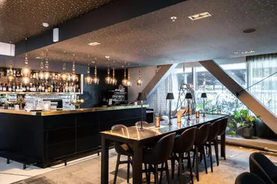 a bar with a wooden table and chairs at Scandic Ørnen in Bergen
