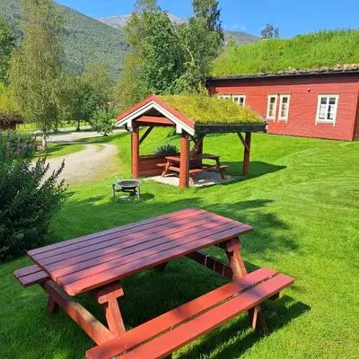 a picnic table and a gazebo in a yard at Lensmansgarden in Innfjorden