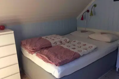 a small bedroom with a bed with white sheets at Flohytta in Stryn