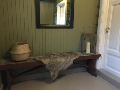 a bench in the corner of a room with a mirror at Bakka in Bakka